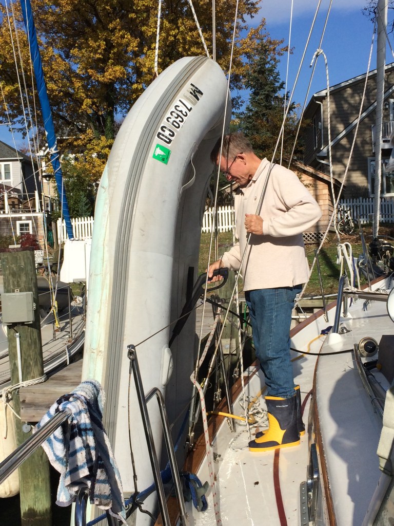 Readying the boat . . . putting the dinghy up on the bow for storage.